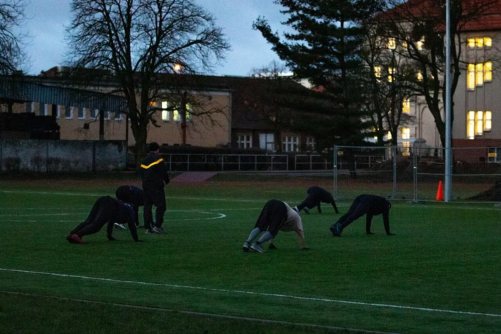A group doing bodyweight exercises on a field